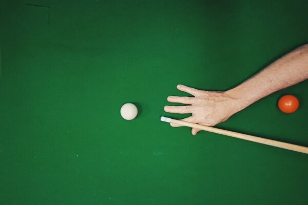 Pool player aiming with a cue over a billiard table; editorial image for new Cuetec cue comparison